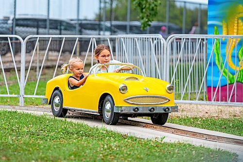 NIC ADAM / FREE PRESS
Zoey (left) and Lexi Voth have fun driving the miniature cars at Tinker Town Monday.
240826 - Monday, August 26, 2024.

Reporter: ?