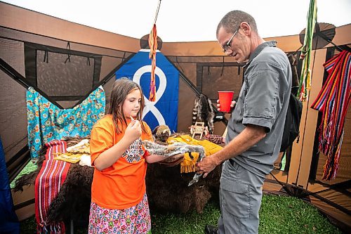 MIKAELA MACKENZIE / WINNIPEG FREE PRESS
	
Breezie Clemons (eight) and her grandpa, Dennis Duguid, check out furs in the trapping tent at the 6th annual Manitoba Mtis Federation elders and youth gathering at Selkirk Park on Tuesday, Aug. 27, 2024. The gathering brings together elders and youth from across the regions so that the youth can learn traditional skills, hear oral teachings and learn the principles of culturally-focused interactions with knowledge keepers.

Standup.
Winnipeg Free Press 2024