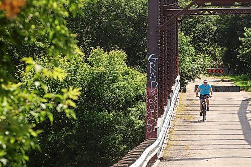 27082024
A cyclist makes their way across the steel through truss bridge, which has long been closed to vehicle traffic, in Wawanesa on a warm Tuesday afternoon. 
(Tim Smith/The Brandon Sun)