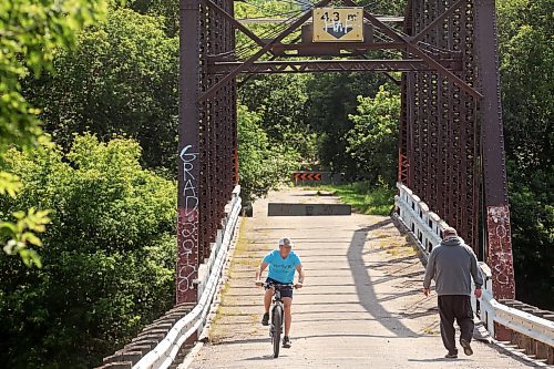 27082024
A cyclist and a pedestrian make their way across the steel through truss bridge, which has long been closed to vehicle traffic, in Wawanesa on a warm Tuesday afternoon. 
(Tim Smith/The Brandon Sun)