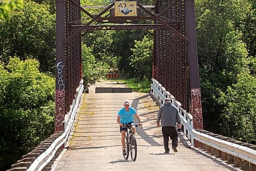 27082024
A cyclist and a pedestrian make their way across the steel through truss bridge, which has long been closed to vehicle traffic, in Wawanesa on a warm Tuesday afternoon. 
(Tim Smith/The Brandon Sun)