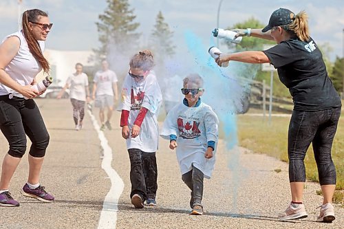 Janelle Boyd and Paula Planetta with Shilo personnel support programs cover runners with coloured powder during the CFB Shilo Fun Run 2024 hosted by CFB Shilo Community Recreation and the Shilo Military Family Resource Centre on Thursday. Donations were taken for cancer research as part of the run and a free barbecue was served after. (Tim Smith/The Brandon Sun)