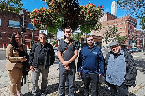 Emmy Sanderson of Brandon Downtown BIZ lead Greg Burnett, Matt Sanscartier and Matt Halchakar of Winnipeg's Downtown Community Safety Partnership and Kevin Walker of Bear Clan Patrol on a walking tour of downtown Brandon on Thursday. (Colin Slark/The Brandon Sun)