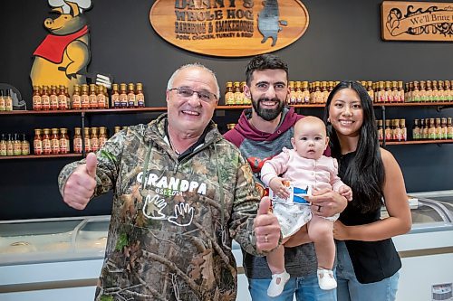 BROOK JONES ./ FREE PRESS
Danny Kleinsasser, 62, (left) of Danny's Whole Hog Barbecue &amp; Smokehouse gives two thumbs up as he is pictured with his son Isaiah Kleinsasser, 25, his daughter-in-law Kaeziah Kleinsasser, 24, and his granddaughter seven-month-old Ariyah Kleinsasser. Kleinsasser and his family are pictured at the family's retail store at 12045 PTH 67 in the RM of Rockwood, Man., Thursday, Aug. 29, 2024.