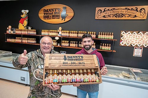 BROOK JONES ./ FREE PRESS
Danny Kleinsasser, 62, (left) of Danny's Whole Hog Barbecue &amp; Smokehouse gives a thumbs up as he is pictured holding various flavours of Danny's Own Barbecue Sauce with his son Isaiah Kleinsasser, 25, while standing in their retail store at 12045 PTH 67 in the RM of Rockwood, Man., Thursday, Aug. 29, 2024.