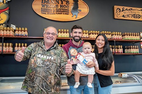 BROOK JONES ./ FREE PRESS
Danny Kleinsasser, 62, (left) of Danny's Whole Hog Barbecue &amp; Smokehouse gives two thumbs up as he is pictured with his son Isaiah Kleinsasser, 25, his daughter-in-law Kaeziah Kleinsasser, 24, and his granddaughter seven-month-old Ariyah Kleinsasser. Kleinsasser and his family are pictured at family's retail store at 12045 PTH 67 in the RM of Rockwood, Man., Thursday, Aug. 29, 2024.