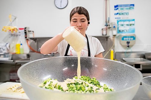 BROOK JONES ./ FREE PRESS
Cassidy Kleinsasser, 14, who is the youngest daughter of Danny Kleinsasser of Danny's Whole Hog Barbecue &amp; Smokehouse is pictured adding caesar dressing to a broccoli and cauliflower salade at the family's operation at 12045 PTH 67 in the RM of Rockwood, Man., Thursday, Aug. 29, 2024.