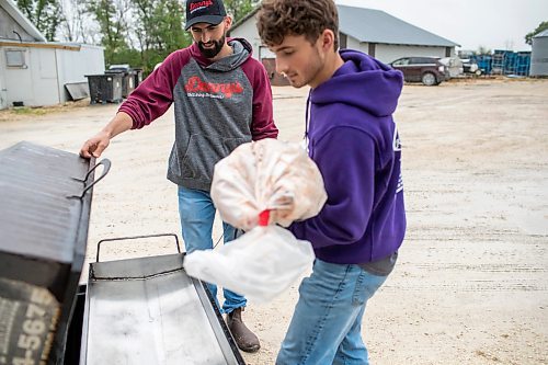 BROOK JONES ./ FREE PRESS
Ezra Kleinsasser, 18, (right) loads a hog onto a do it yourself cooker as his brother Isaiah Kleinsasser, 25, looks on. The brothers are the son's of Danny Kleinsasser of Danny's Whole Hog Barbecue &amp; Smokehouse and are pictured at the family's operation at 12045 PTH 67 in the RM of Rockwood, Man., Thursday, Aug. 29, 2024.