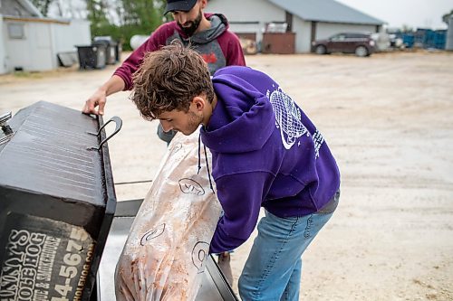 BROOK JONES ./ FREE PRESS
Ezra Kleinsasser, 18, (right) loads a hog onto a do it yourself cooker as his brother Isaiah Kleinsasser, 25, looks on. The brothers are the son's of Danny Kleinsasser of Danny's Whole Hog Barbecue &amp; Smokehouse and are pictured at the family's operation at 12045 PTH 67 in the RM of Rockwood, Man., Thursday, Aug. 29, 2024.