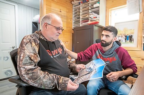 BROOK JONES ./ FREE PRESS
Danny Kleinsasser, 62, (left) show emotion as he looks at photos of the pickup truck he was driving which was T-boned by a gravel truck in March 2024. His son Isaiah Kleinsasser, 25, comforts Danny of Danny's Whole Hog Barbecue &amp; Smokehouse at the family's operation in the RM of Rockwood, Man., Thursday, Aug. 29, 2024.