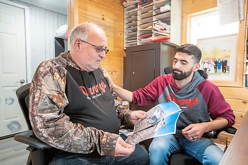 BROOK JONES ./ FREE PRESS
Danny Kleinsasser, 62, (left) show emotion as he looks at photos of the pickup truck he was driving which was T-boned by a gravel truck in March 2024. His son Isaiah Kleinsasser, 25, comforts Danny of Danny's Whole Hog Barbecue &amp; Smokehouse at the family's operation in the RM of Rockwood, Man., Thursday, Aug. 29, 2024.