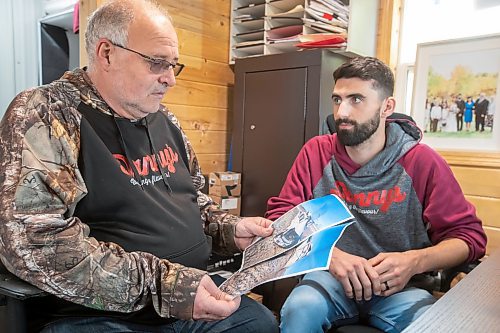 BROOK JONES ./ FREE PRESS
Danny Kleinsasser, 62, (left) looks at photos of the pickup truck he was driving which was T-boned by a gravel truck in March 2024. His son Isaiah Kleinsasser, 25, comforts Danny of Danny's Whole Hog Barbecue &amp; Smokehouse at the family's operation in the RM of Rockwood, Man., Thursday, Aug. 29, 2024.