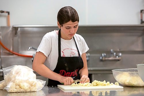 BROOK JONES ./ FREE PRESS
Cassidy Kleinsasser, 14, who is the youngest daughter of Danny Kleinsasser of Danny's Whole Hog Barbecue &amp; Smokehouse is pictured cutting cauliflower for a broccoli and cauliflower salade at the family's operation at 12045 PTH 67 in the RM of Rockwood, Man., Thursday, Aug. 29, 2024.