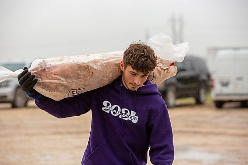 BROOK JONES ./ FREE PRESS
Ezra Kleinsasser, 18, who is the son of Danny Kleinsasser, 62, of Danny's Whole Hog Barbecue &amp; Smokehouse carries a hog as he is pictured at the family's operation at 12045 PTH 67 in the RM of Rockwood, Man., Thursday, Aug. 29, 2024.