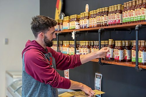 BROOK JONES ./ FREE PRESS
Isaiah Kleinsasser, 25, of Danny's Whole Hog Barbecue &amp; Smokehouse stocks a variety of flavours of Danny's Own Barbecue Sauce as he stands in the family's retail store at 12045 PTH 67 in the RM of Rockwood, Man., Thursday, Aug. 29, 2024.