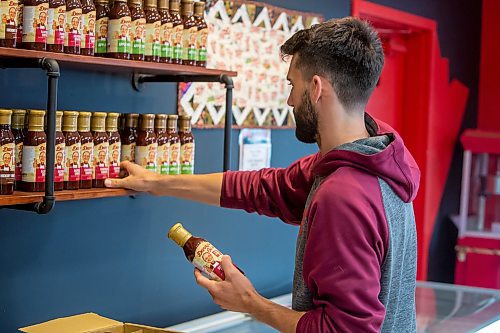 BROOK JONES ./ FREE PRESS
Isaiah Kleinsasser, 25, of Danny's Whole Hog Barbecue &amp; Smokehouse stocks a variety of flavours of Danny's Own Barbecue Sauce as he stands in the family's retail store at 12045 PTH 67 in the RM of Rockwood, Man., Thursday, Aug. 29, 2024.