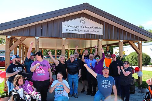 Brandon’s Ken Gordon (Centre, wearing a dark shirt and blue jeans) stands beside Terri Silvius, executive director of COR Enterprises (on left) and several participants of COR Enterprises Inc. With Gordon's $90,000 donation, an open-air gazebo was recently next to COR's main building. (Michele McDougall/The Brandon Sun)
