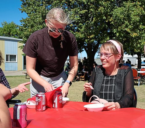 Tannis Figol, a participant at COR Enterprises in Brandon, smiles as she enjoys a piece of cake during Friday's the grand opening. (Michele McDougall/The Brandon Sun)
