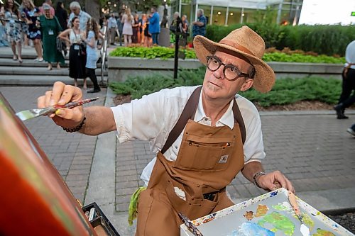 BROOK JONES / FREE PRESS
Artist Andrew S. Hiebert of Ignite Your Imagination focuses as he paints an acrylic painting during A Picnic in Provence - Garden Party 2024 at the Leo Mol Sculpture Garden at Assiniboine Park in Winnipeg, Man., Wednesday, Aug. 28, 2024. The annual fundraiser supports the Assiniboine Park Conservancy and this year's event included 500 guests.