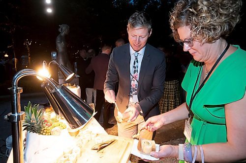 BROOK JONES / FREE PRESS
Leighton Klassen and Colleen Pylypuik, who are both Colliers Project Leaders, are pictured adding toppings to their French Hot Dogs as they attend A Picnic in Provence - Garden Party 2024 at the Leo Mol Sculpture Garden at Assiniboine Park in Winnipeg, Man., Wednesday, Aug. 28, 2024. The annual fundraiser supports the Assiniboine Park Conservancy and this year's event included 500 guests.