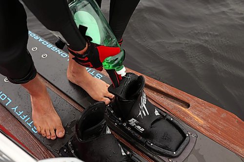 29082024
Casey Mommer uses dish soap to ease his feet into the tight bindings of his waterskis. 
(Tim Smith/The Brandon Sun)