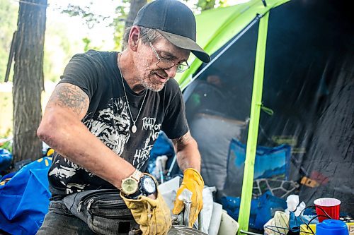 MIKAELA MACKENZIE / WINNIPEG FREE PRESS

Encampment resident Terry Johnsen talks to the Free Press while separating metal for recycling at Fort Rouge Park on Tuesday, Sept. 3, 2024. A police vehicle hit a woman, who later died of her injuries, on their way down to the encampment last night.

For Nicole story.
Winnipeg Free Press 2024