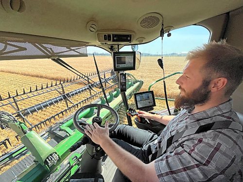 Neil Waldner of Hillside Hutterite Colony operates his community's newest combine on an 80-acre wheat field north of Brandon during a late summer harvest on Wednesday afternoon. (Matt Goerzen/The Brandon Sun)