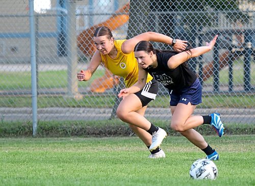 Goalkeeper Josie Black, left, and Ashley Robinson race to a ball during warmup for practice on Tuesday. (Thomas Friesen/The Brandon Sun)