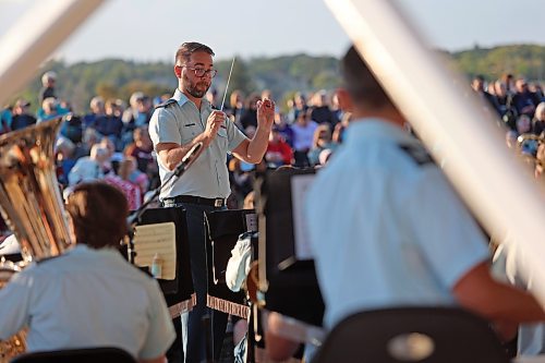 Capt. Devin Sloos, the conductor of the Royal Canadian Air Force Band, leads the players on stage at Riverbank Discovery Centre during a free show on Thursday evening put on by the City of Brandon. Hundreds of audience members gathered to hear songs like "Boomba," "Sail Away" and "Africa." (Connor McDowell/Brandon Sun)