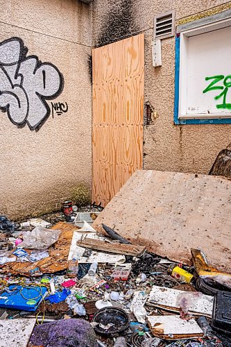 NIC ADAM / FREE PRESS
Garbage, among it used needles, litters the ground near the burned apartment at Centre Village, an inner-city subsidized housing complex once lauded for its design that was left to rot and became a hub for criminal activity, after it caught fire Wednesday night amid concerns about squatters and criminal activity there. 
240905 - Thursday, September 05, 2024.

Reporter: Malak