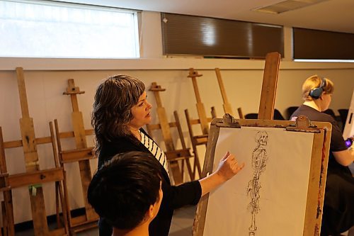 BU Art Prof Lisa Wood teaches a student how to draw human skeleton during Thursday art class. Wood says nude models provide valuable experience for dtudents to learn the structure and anatomy of the human body. (Abiola Odutola/The Brandon Sun)