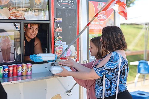 Delicious Catrachos owner Sadia Pereiai (left) sells food to Olivia Loewen and her mother, Ruth, from her truck at the Downtown Summer Market on Friday afternoon. (Abiola Odutola/The Brandon Sun)