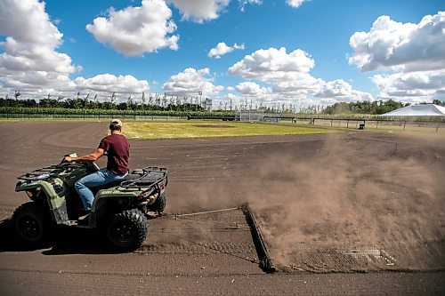 Jace Guilford drags the infield at the Field of Dreams baseball diamond near Clearwater, Manitoba on Thursday. (Mikaela MacKenzie/Winnipeg Free Press)