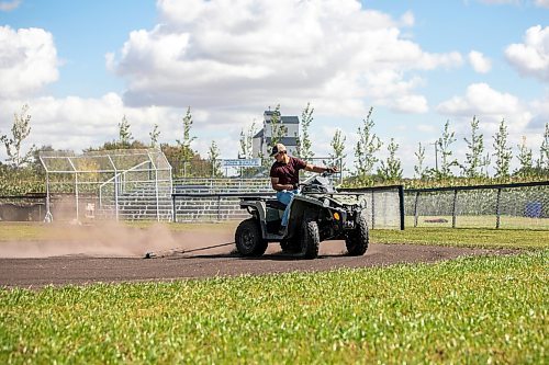 Jace Guilford drags the infield at the Field of Dreams baseball diamond near Clearwater, Manitoba on Thursday. (Mikaela MacKenzie/Winnipeg Free Press)