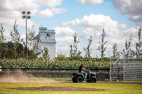 Jace Guilford drags the infield at the Field of Dreams baseball diamond near Clearwater, Manitoba on Thursday. (Mikaela MacKenzie/Winnipeg Free Press)