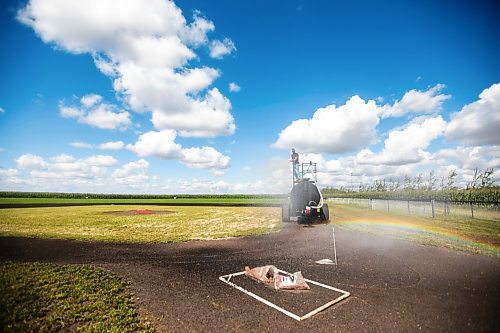 MIKAELA MACKENZIE / WINNIPEG FREE PRESS

A rainbow forms over home plate as Jace Guilford waters the infield at the Field of Dreams baseball diamond near Clearwater, Manitoba on Thursday, Sept. 5, 2024. 

For Mike McIntyre story.
Winnipeg Free Press 2024