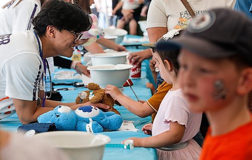 JOHN WOODS / FREE PRESS
Andrew Lee, medical student, checks the reflexes of a stuffy with a child at the Teddy Bears&#x2019; Picnic in Assiniboine Park  Sunday, September 8, 2024. 

Reporter: tyler