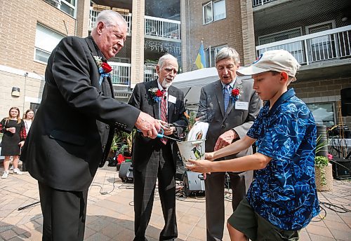 JOHN WOODS / FREE PRESS
Eugene Hyworon, Villa Board president, centre, is joined by board members Rod Noseworthy, left, and Dale Fuga, right, and his grandson Andriyan Hyworon as they burn the mortgage for St Mary The Protectress Millennium Villa during a community celebration Sunday, September 8, 2024. The  church and senior communities came together to celebrate paying off their villa&#x573; 35 year mortgage.

Reporter: standup