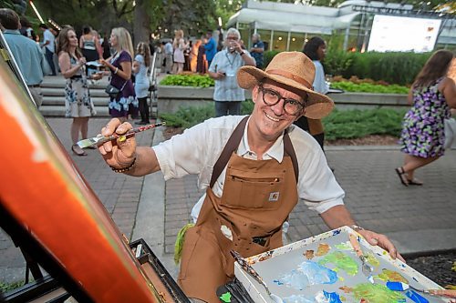 BROOK JONES / FREE PRESS
Artist Andrew S. Hiebert of Ignite Your Imagination is all smiles as paints an acrylic painting during A Picnic in Provence - Garden Party 2024 at the Leo Mol Sculpture Garden at Assiniboine Park in Winnipeg, Man., Wednesday, Aug. 28, 2024. The annual fundraiser supports the Assiniboine Park Conservancy and this year's event included 500 guests.