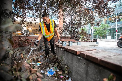 MIKAELA MACKENZIE / WINNIPEG FREE PRESS

Downtown Winnipeg BIZ Enviro Team member Jeremy Roulette cleans trash from behind the bench at Carlton and Graham on Wednesday, Sept. 4, 2024. 

For Malak story.
Winnipeg Free Press 2024