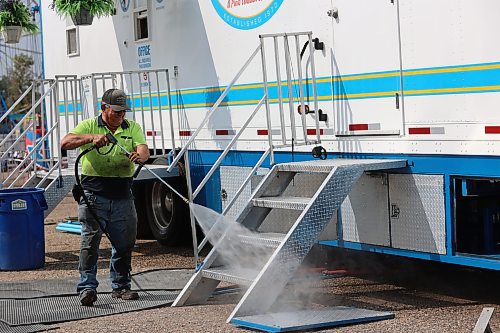 Select Shows president Jim Mills sprays the stairs of his truck with water in preparation for the 2024 Food Truck Warz at the Keystone Centre on Thursday afternoon. (Abiola Odutola/The Brandon Sun)