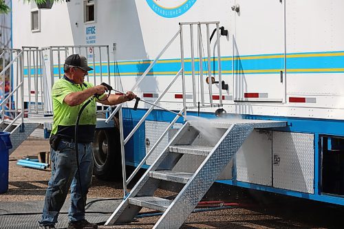 Select Shows president Jim Mills sprays his truck with water in preparation for the 2024 Food Truck Warz at the Keystone Centre on Thursday afternoon. (Abiola Odutola/The Brandon Sun)