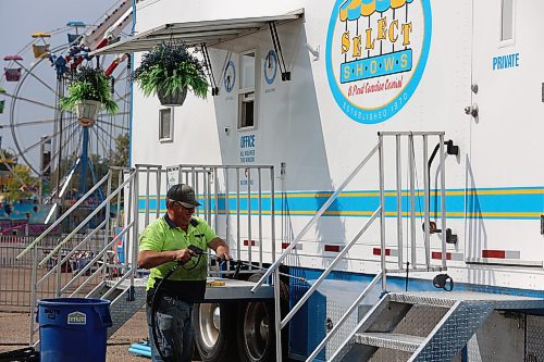 Select Shows president Jim Mills sprays his truck with water in preparation for the 2024 Food Truck Warz at the Keystone Centre on Thursday afternoon. (Abiola Odutola/The Brandon Sun)