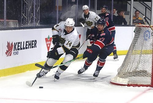 Brandon Wheat Kings defenceman Adam Belusko (14) carries the puck around the Brandon net with Regina Pats forward Cohen Klassen (37) in hot pursuit during the first period of Western Hockey League pre-season action at Westoba Place on Friday. (Perry Bergson/The Brandon Sun)