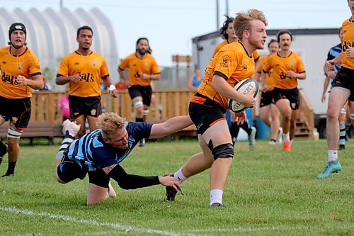 Brandon Barbarians Bryson McNish dives to tackle Manitoba Wombats Mike Dynkavitch during their Rugby Manitoba men's Division 2 semifinal at John Reilly Field on Saturday. (Thomas Friesen/The Brandon Sun)