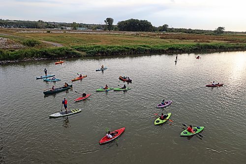 Canoes, kayaks and paddleboards sail down the Assiniboine River from the Riverbank Discovery Centre as part of Paddlefest on Saturday evening. (Colin Slark/The Brandon Sun)