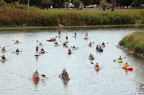 Canoes, kayaks and paddleboards sail down the Assiniboine River from the Riverbank Discovery Centre as part of Paddlefest on Saturday evening. (Colin Slark/The Brandon Sun)