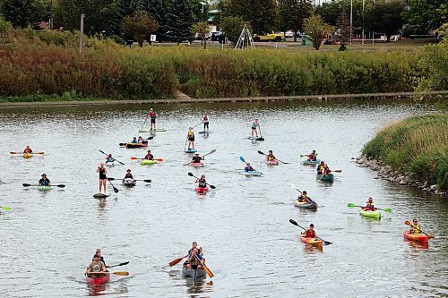 Canoes, kayaks and paddleboards sail down the Assiniboine River from the Riverbank Discovery Centre as part of Paddlefest on Saturday evening. (Colin Slark/The Brandon Sun)