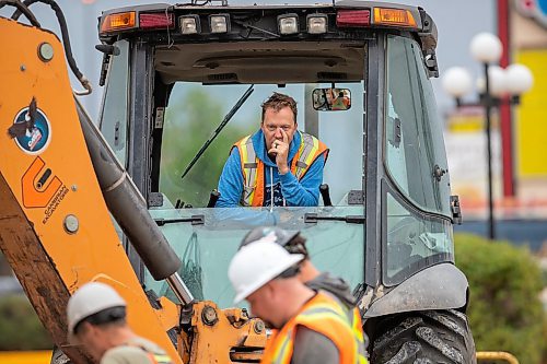 BROOK JONES / FREE PRESS
Daryl Lucking who is an excavator operator with Cambrian Excavators LTD., waits as fellow work crew members inspect the hole he dug at the corner of Pembina Highway and Adamar Road in Winnipeg, Man., Monday, Sept. 16, 2024. Cambrian was doing a land drainage (stormwater sewer) repair.