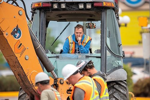 BROOK JONES / FREE PRESS
Daryl Lucking who is an excavator operator with Cambrian Excavators LTD., waits as fellow work crew members inspect the hole he dug at the corner of Pembina Highway and Adamar Road in Winnipeg, Man., Monday, Sept. 16, 2024. Cambrian was doing a land drainage (stormwater sewer) repair.